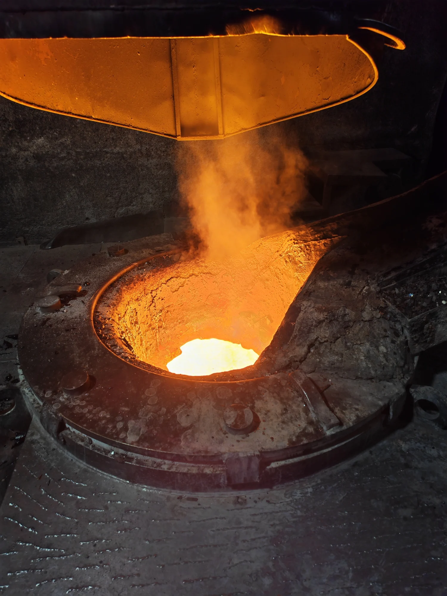 Heißer Schmelzofen mit flüssigem Metall und aufsteigendem Dampf in einer dunklen industriellen Umgebung.