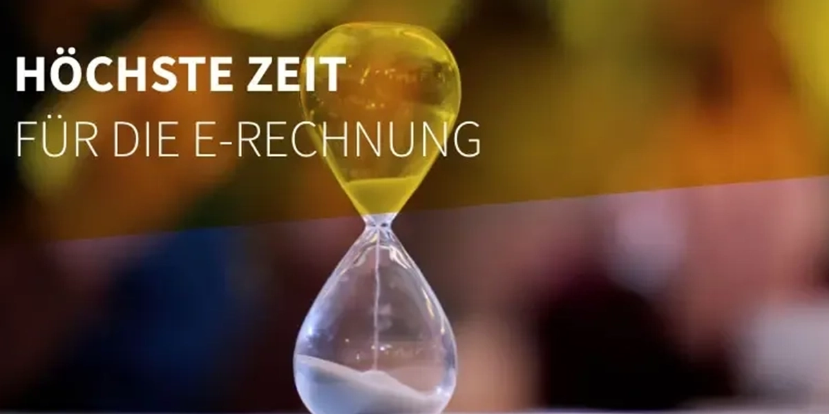 Sanduhr vor unscharfem Hintergrund mit Text: Höchste Zeit für die E-Rechnung.