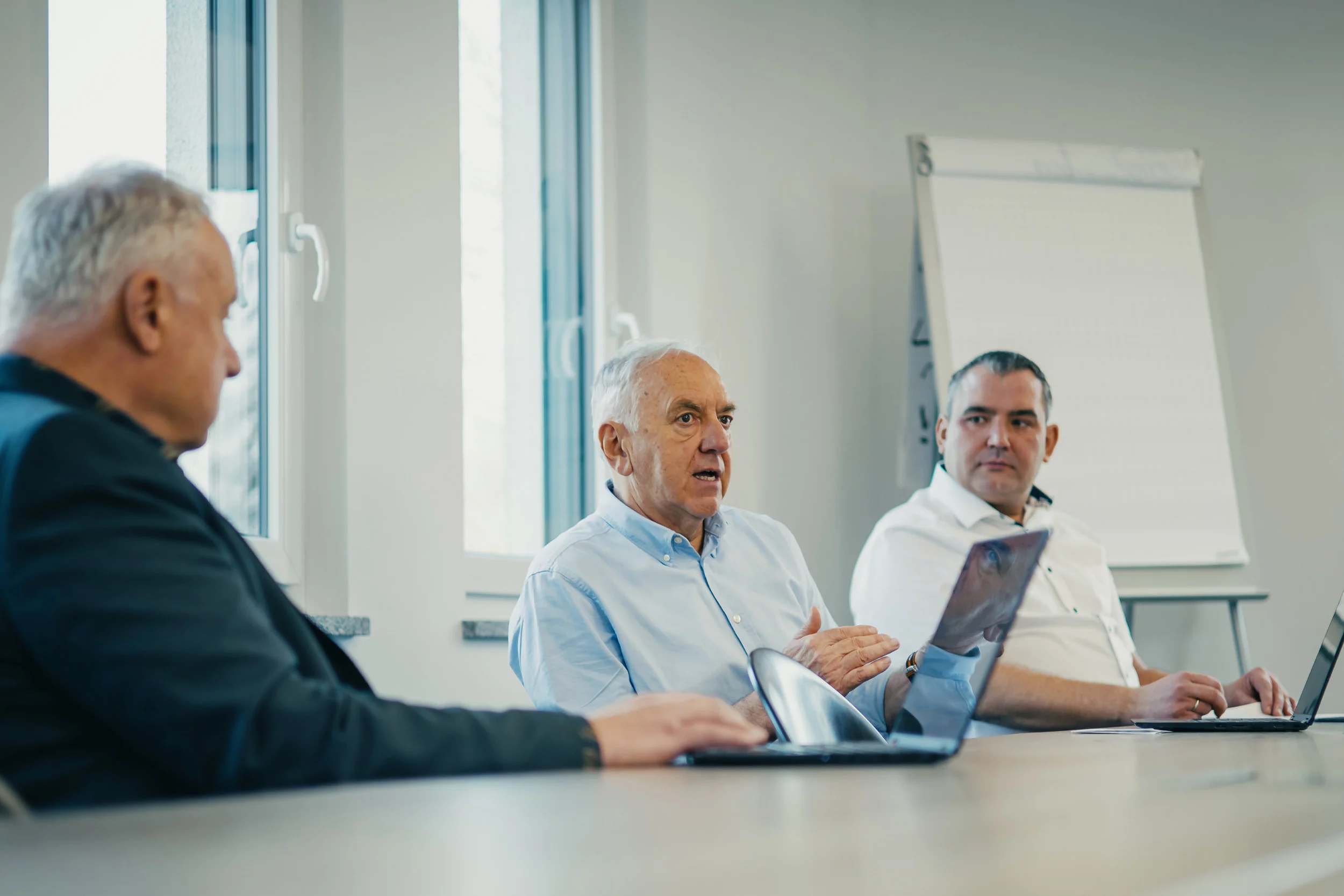 Zwei Männer arbeiten am Computer im Büro, einer zeigt auf den Bildschirm, der andere bewegt die Maus.