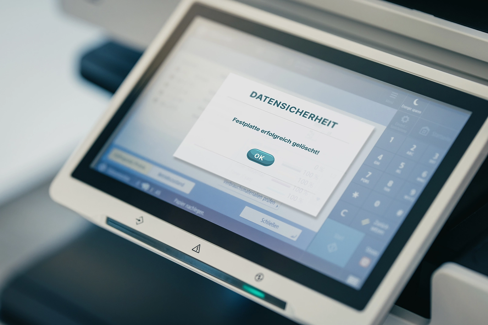 Bild eines Touchscreen-Monitors mit Meldung zur Datensicherheit: Festplatte erfolgreich gelöscht! und OK-Button.