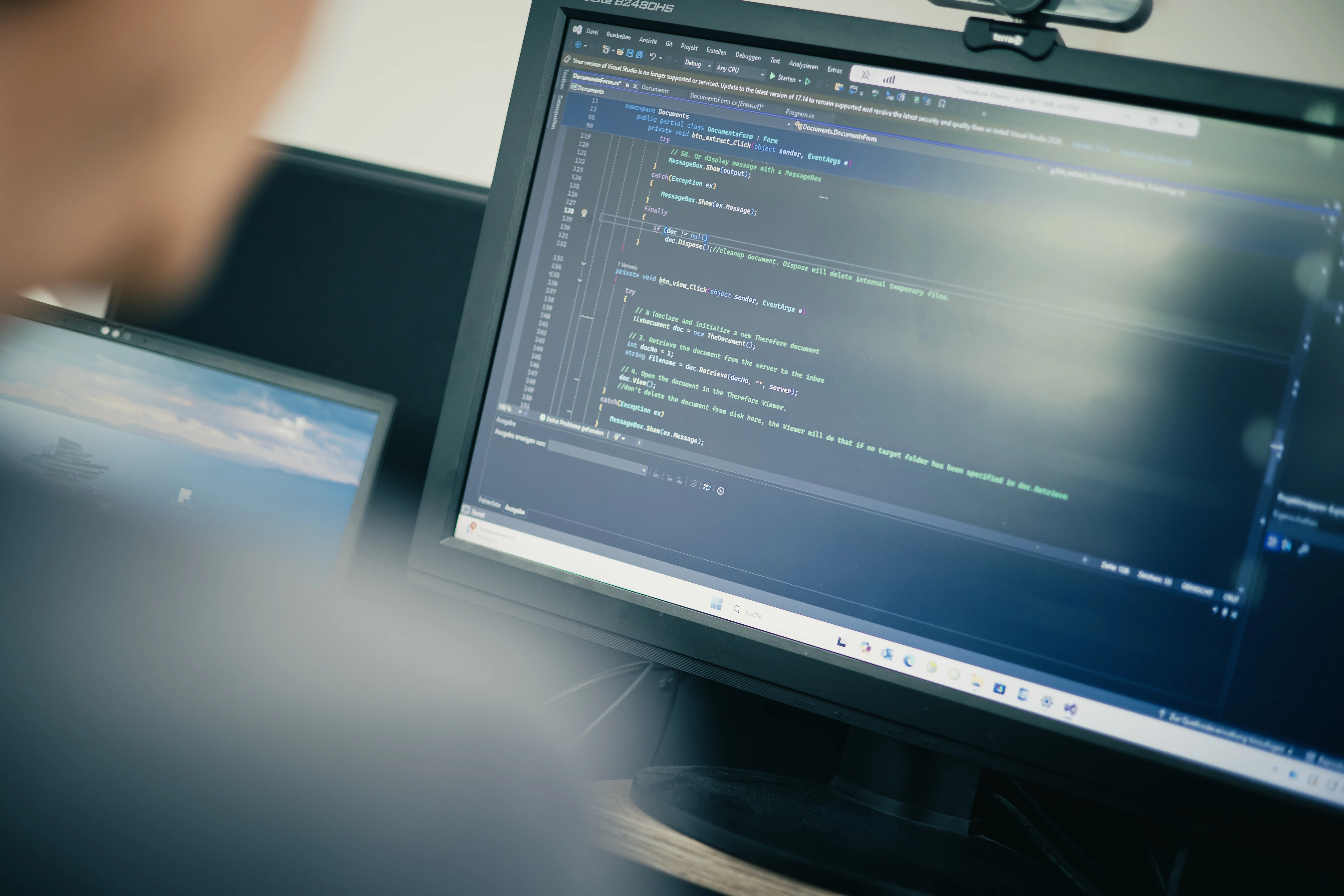 Programmierer arbeitet an einem Computer, das Bild zeigt ein Bildschirm mit Codezeilen in einer Entwicklungsumgebung.